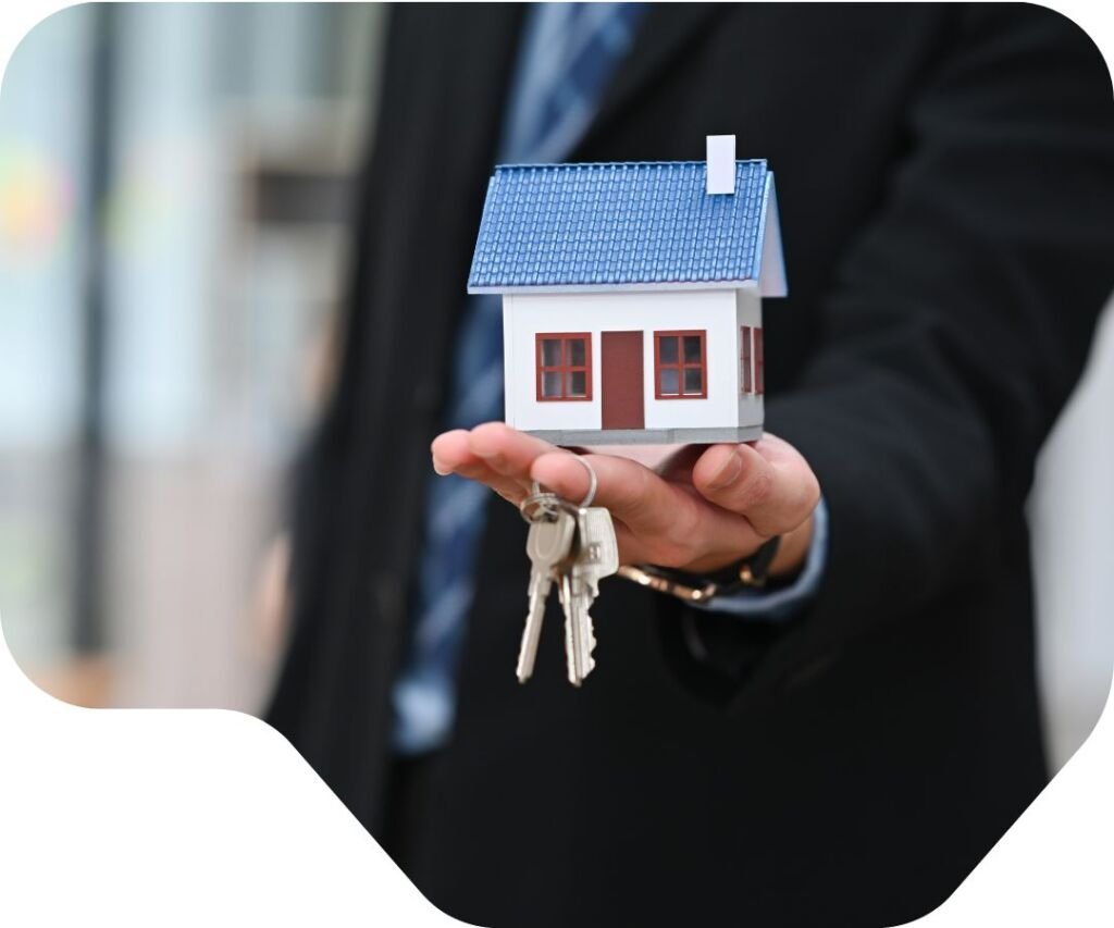 Mortgage lender in business suit holding miniature house model and keys representing verified contact services for home purchase and refinancing