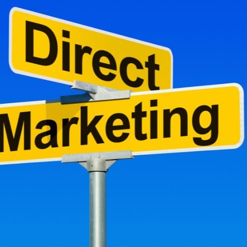 Yellow street signs reading Direct Marketing against blue sky background