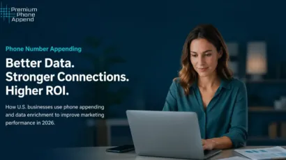 Woman working on laptop at desk reviewing phone appending and data enrichment strategies for marketing